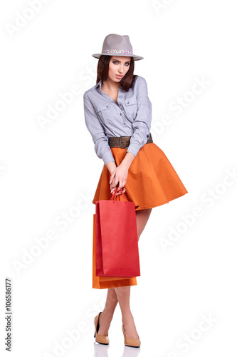 Fashion woman portrait isolated. White background. Happy girl hold shopping bag.