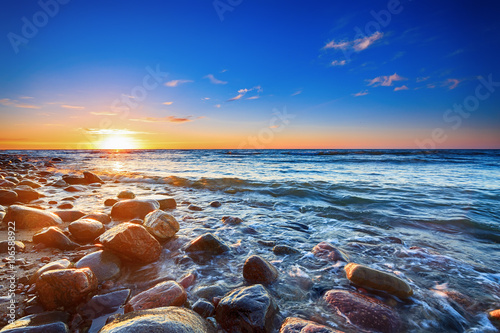 Sunset over the Baltic sea. The pebbly beach in Rozewie.