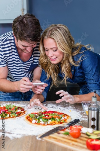 Smiling couple preparing pizza in the kitchen