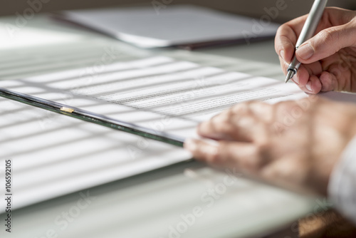 Closeup low angle view of man signing a contract or document