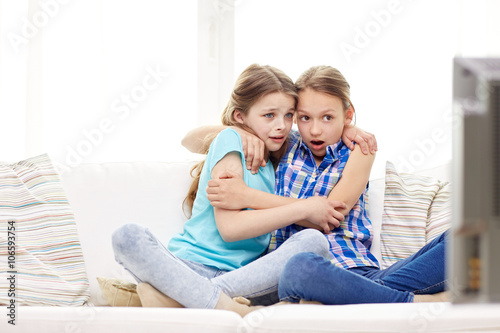 scared little girls watching horror on tv at home