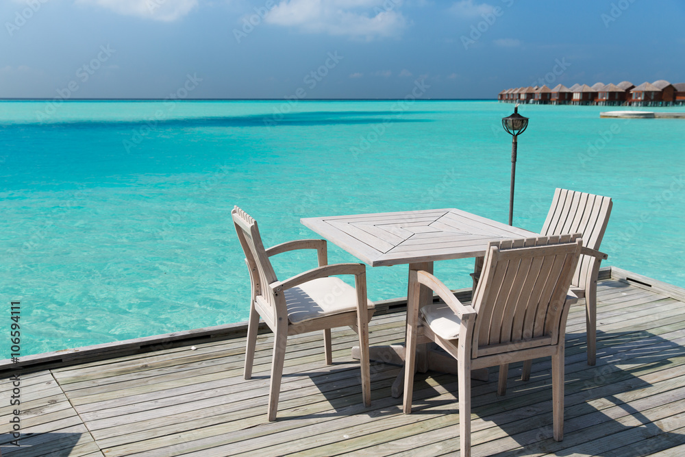 outdoor restaurant terrace with furniture over sea