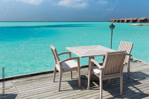 outdoor restaurant terrace with furniture over sea © Syda Productions