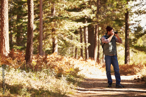 Man taking photographs in forest with copyspace, California, USA © Monkey Business