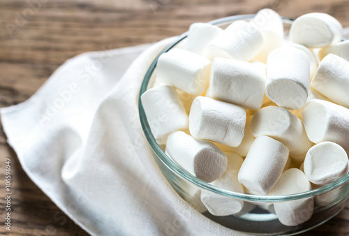 Bowl of marshmallows on the wooden background