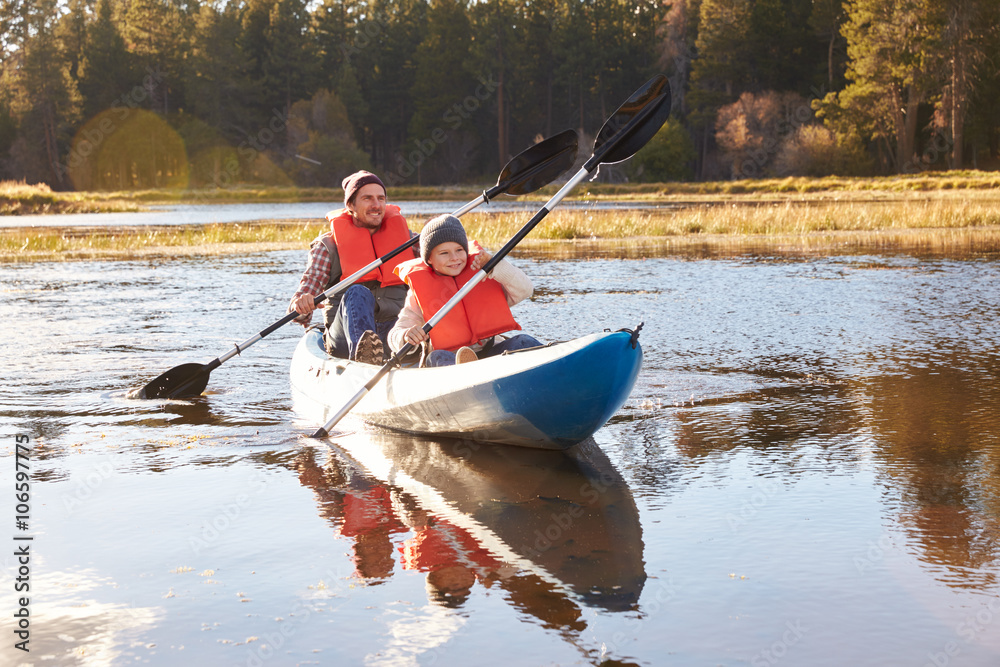 Father and son kayaking on lake, California, USA Father and son kayaking on lake, California, USA
