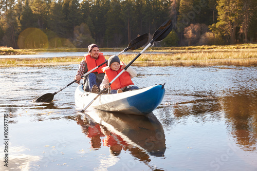 Father and son kayaking on lake, California, USA