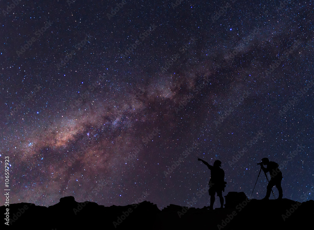 Fototapeta premium Star-catcher. A person is standing next to the Milky Way galaxy