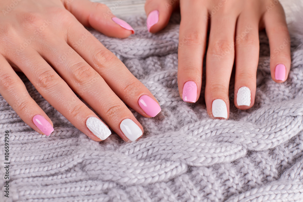 Manicure on handmade knitted background.