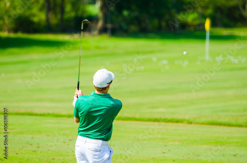 Golfer hitting golf shot.