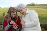 Granny with a teenager girl using mobile phone