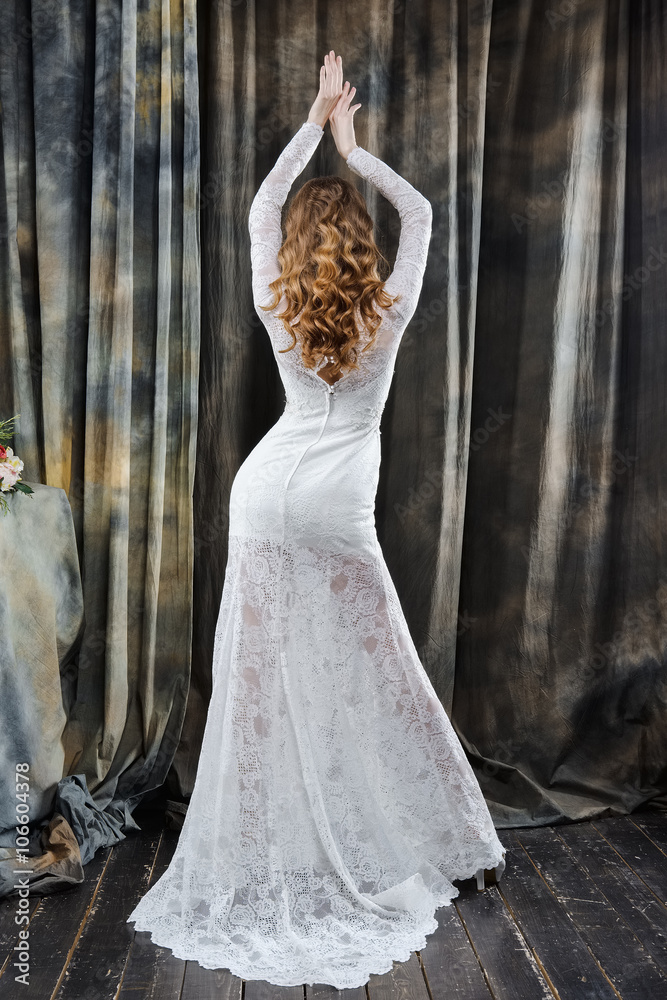 Fototapeta premium portrait of pretty bride in wedding dress with hands up