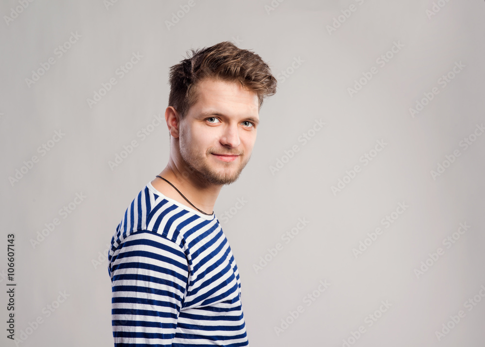 Hipster man in striped t-shirt, gray background, studio shot Hipster man in striped t-shirt, gray background, studio shot