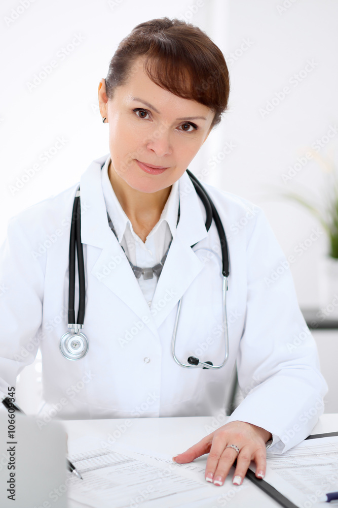 Woman doctor filling up medical history at the desk Woman doctor filling up medical history at the desk
