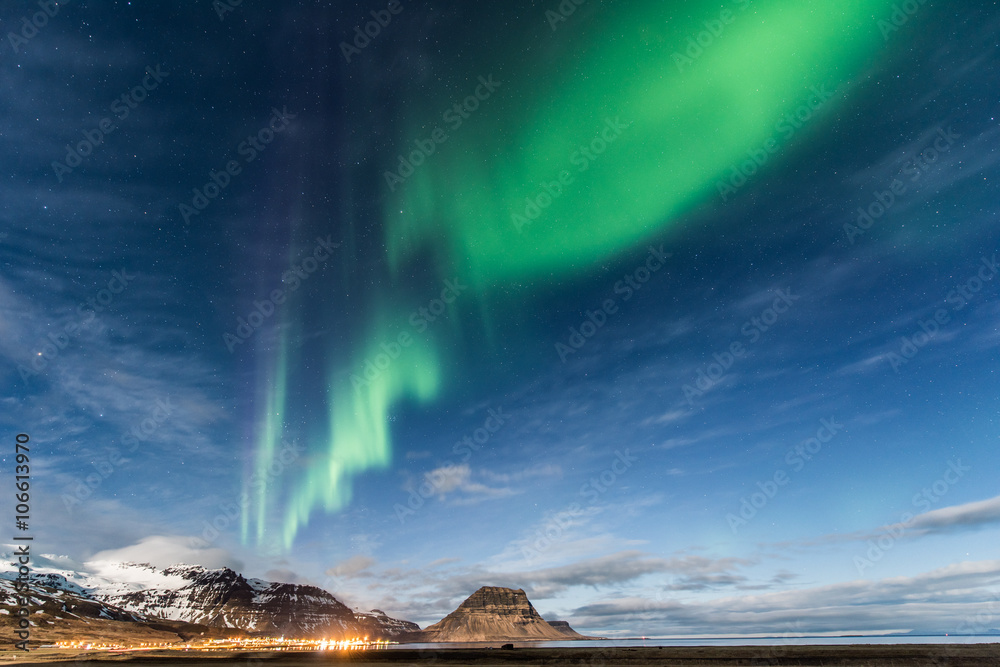 Northern Light over Grundarfjordur town, West Iceland spread through Kirkjufell 