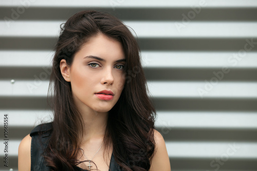 Canvas Print Closeup portrait of young beautiful brunette woman in black leather jacket posin