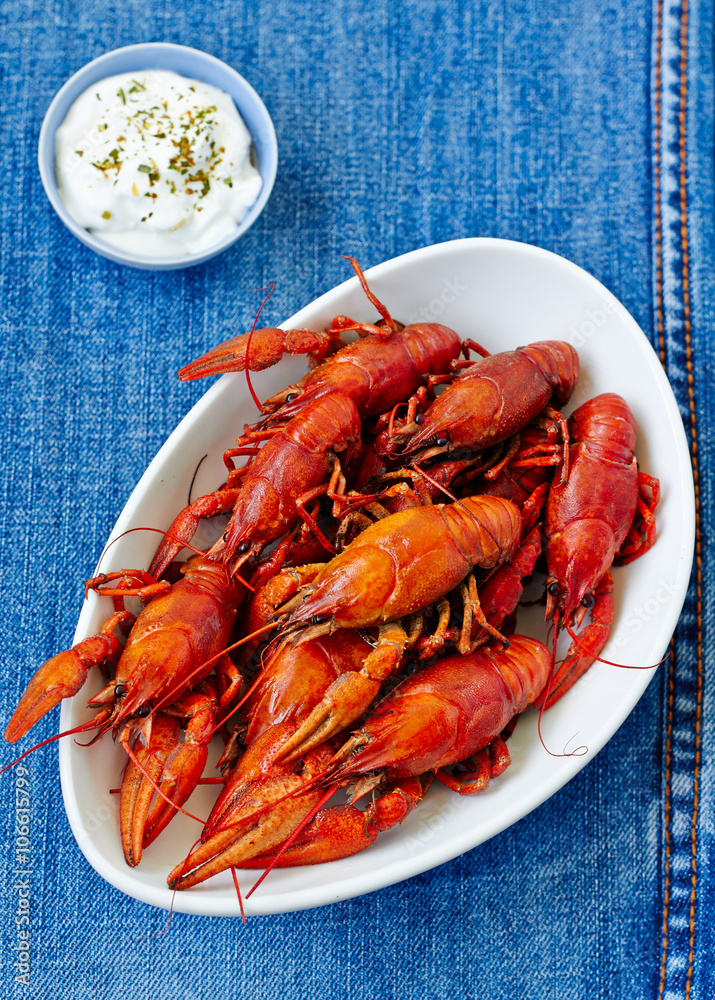 Boiled red crayfish on a white dish with sauce . top view Boiled red crayfish on a white dish with sauce . top view