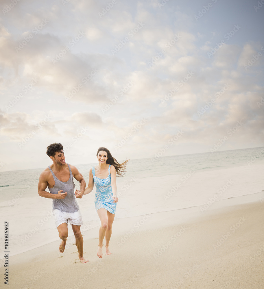 Caucasian couple running on beach Caucasian couple running on beach