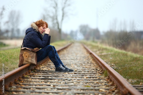 Konstfotografi depression/ depressed woman sitting on a train track seeing no way out