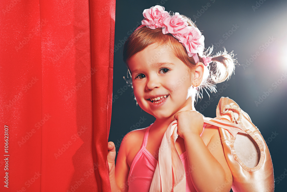 little girl ballerina ballet dancer on stage in red side scenes Stock