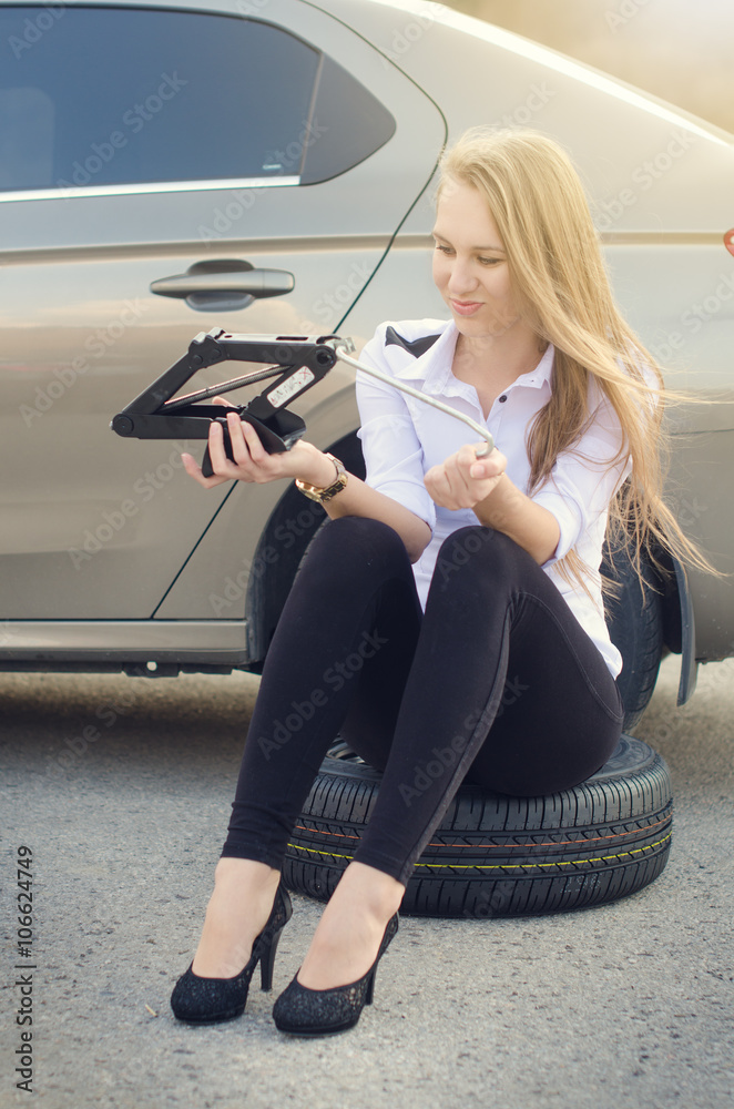 The girl wondered. Broken car on a background. Woman sit on a wheel. Sexy  young woman repair a car. Natural background. Car accident. Stock Photo |  Adobe Stock