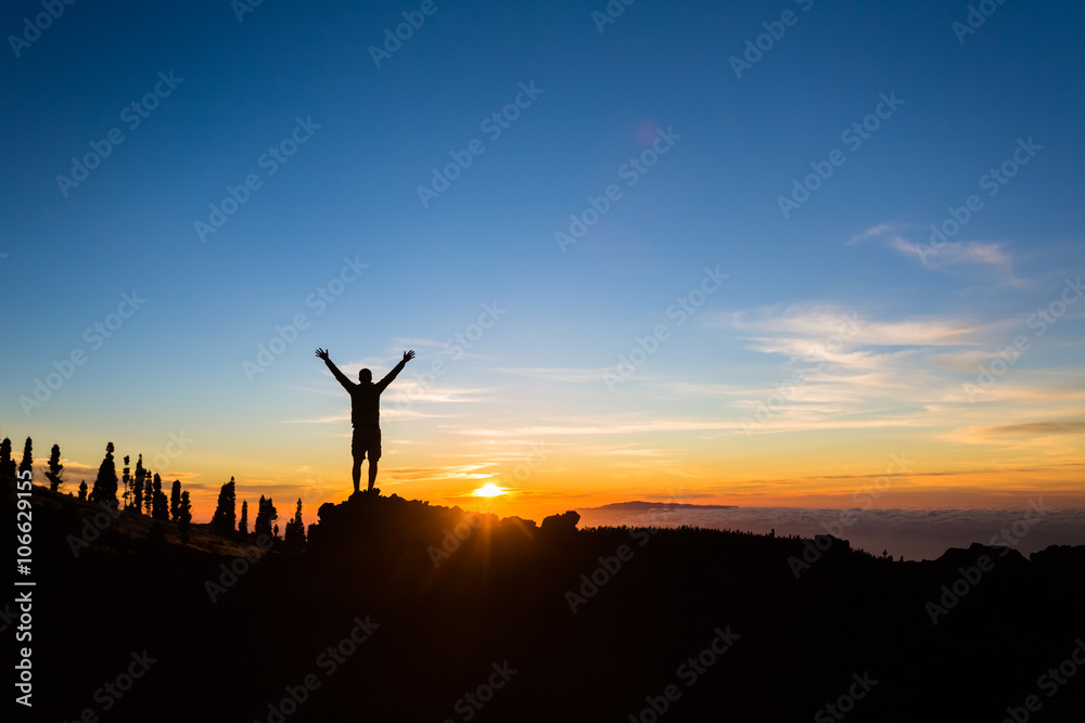 Man hiker silhouette with arms outstretched enjoy mountains