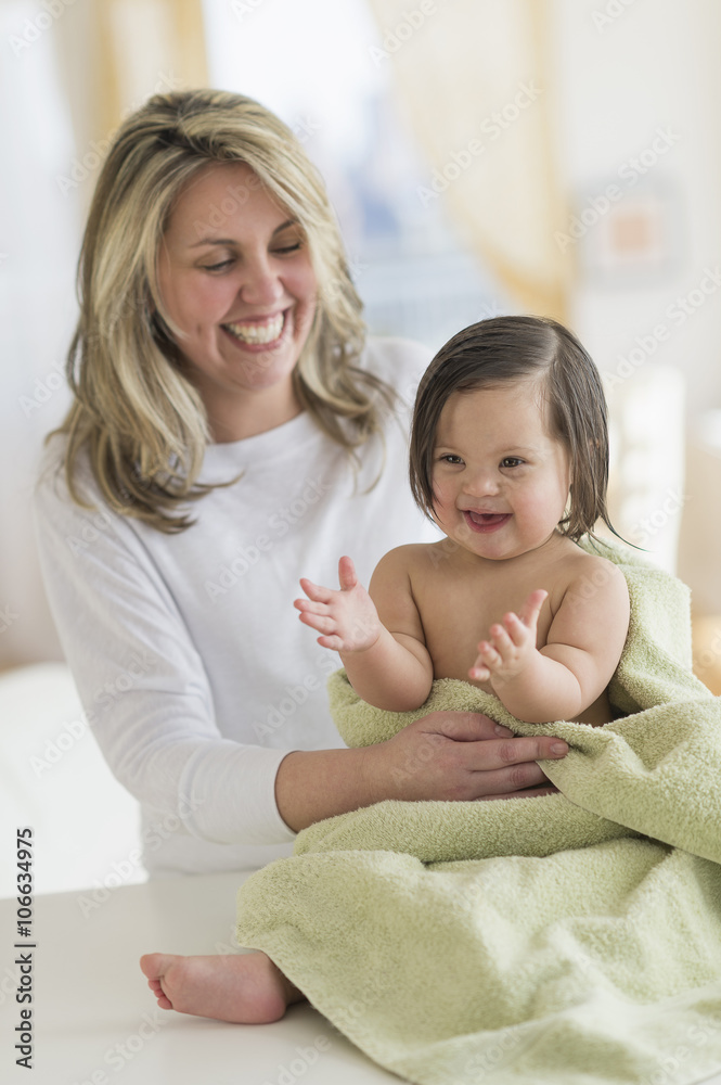 Hispanic mother drying toddler daughter after bath Hispanic mother drying toddler daughter after bath