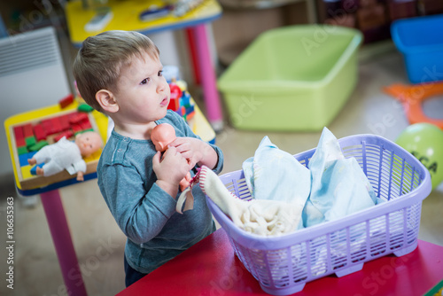 Little boy plays with doll