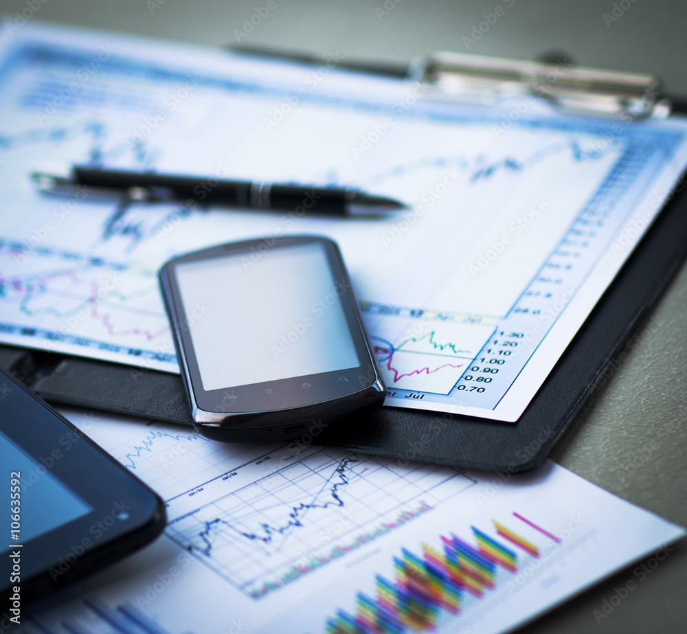 Business chart with smart phone and pen Business chart with smart phone and pen
