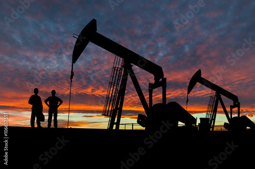 Silhouettes of Pumpjack and Oil Workers in the Oil Field