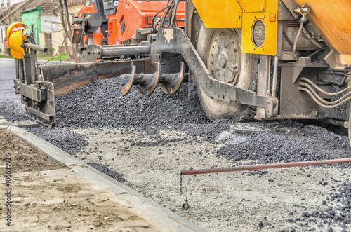 asphalt spreading machine in action photo