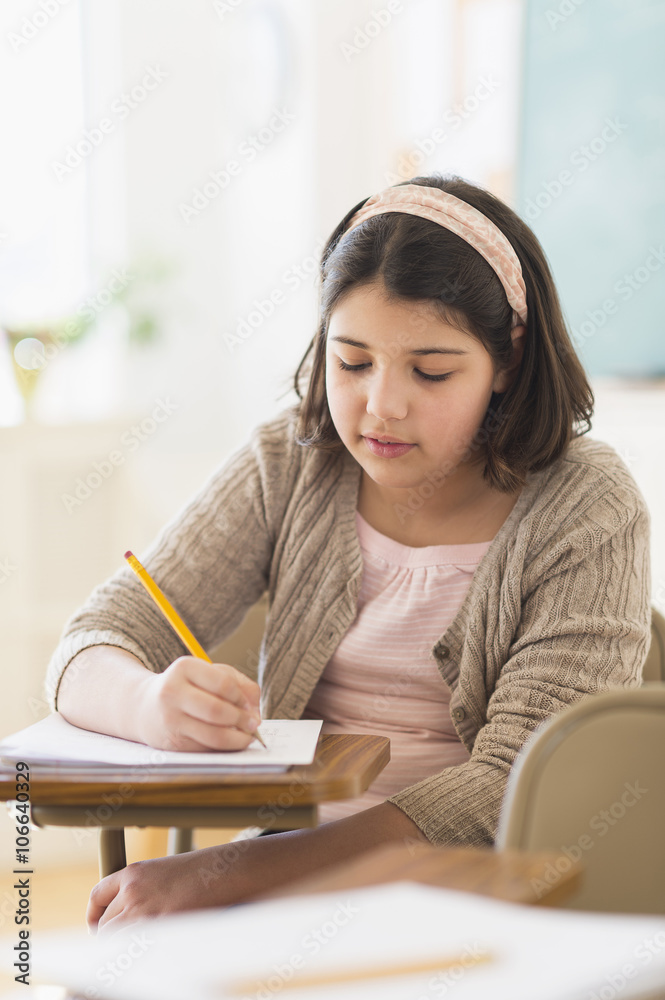 Hispanic girl taking notes in classroom Hispanic girl taking notes in classroom