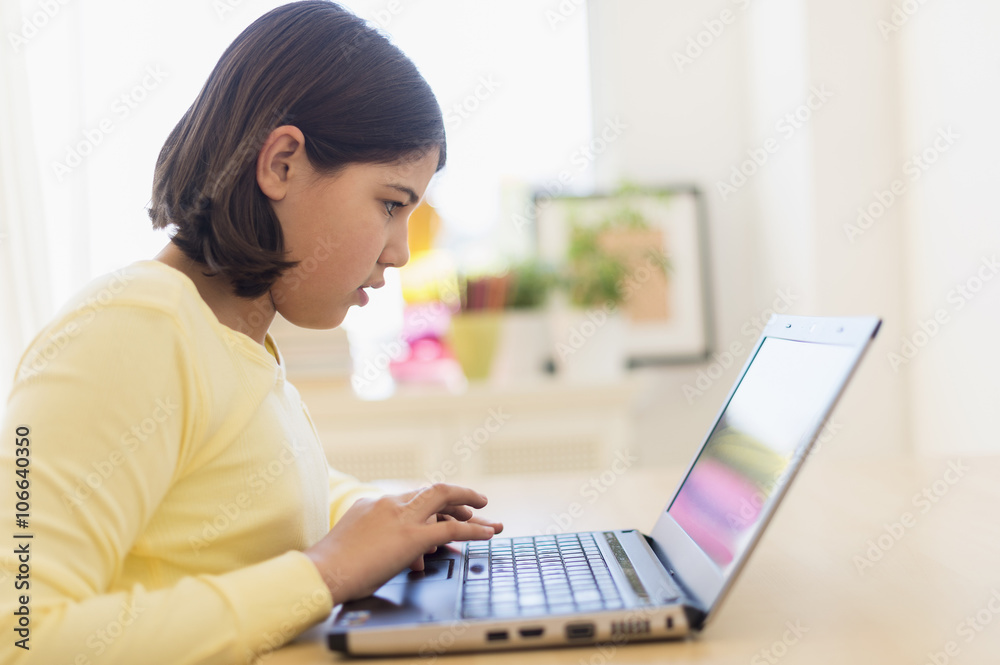 Hispanic girl using laptop at desk Hispanic girl using laptop at desk