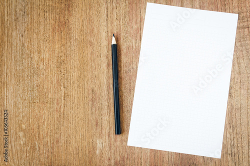 white paper with black pencil on wooden table
