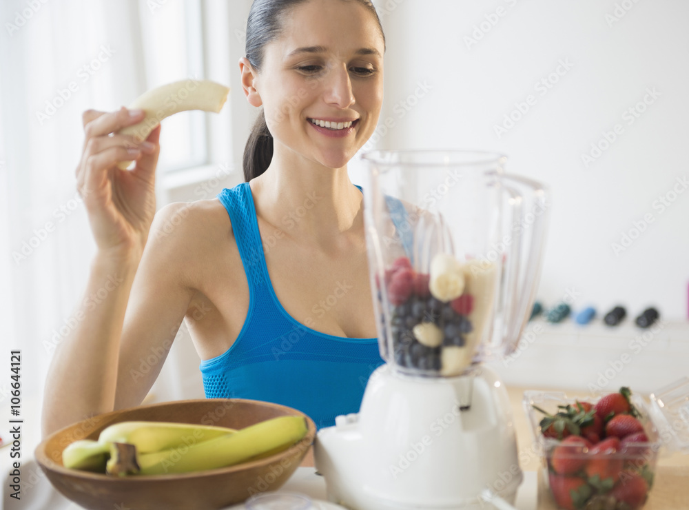 Caucasian woman blending fruit smoothie Caucasian woman blending fruit smoothie