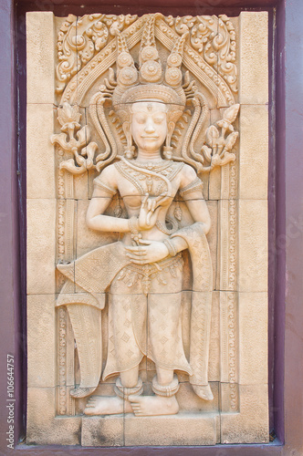 Carving of Hindu god Vishnu standing with photo