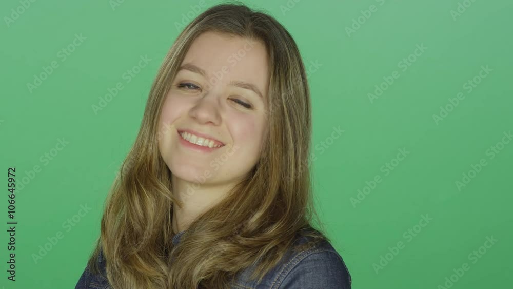 Young woman smiling and laughing, on a green screen studio background Young woman smiling and laughing, on a green screen studio background