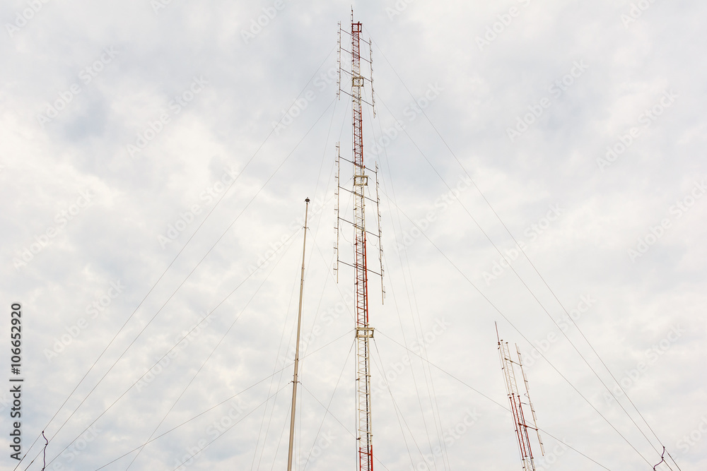 Radio tower with cloudy sky.