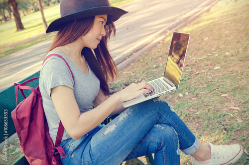 Young woman using laptop in the park outdoor