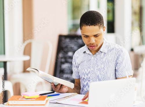 African American man studying at sidewalk cafe