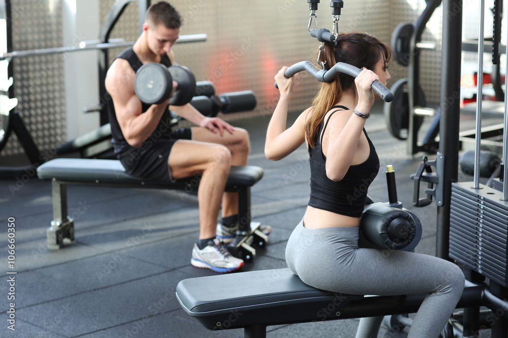 Woman flexing muscles in gym Woman flexing muscles in gym