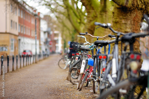 Old bikes parked by a sidewalk