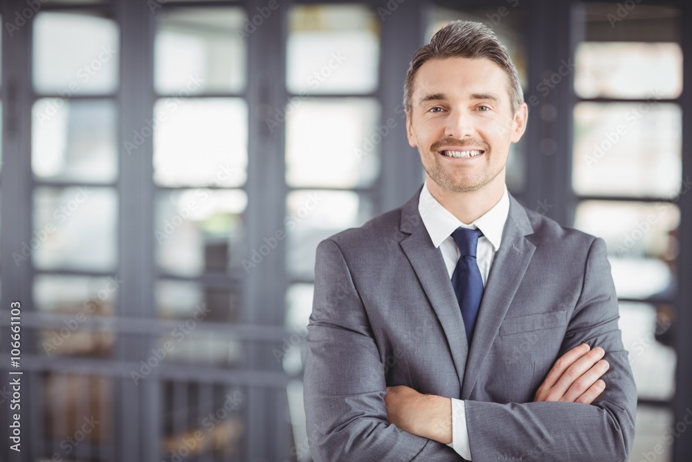 Smiling businessman with arms crossed in office Smiling businessman with arms crossed in office