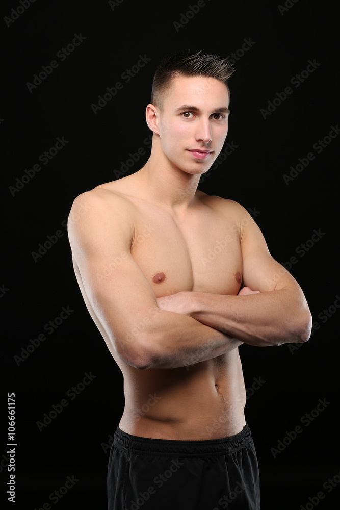 Portrait d'un bel homme torse nu,bras croisés, sur fond noir Photos