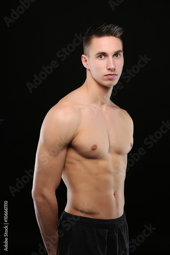 Fotografie Portrait d'un bel homme torse nu sur fond noir