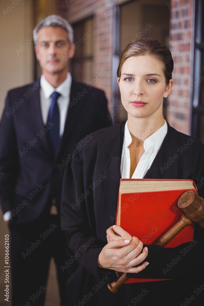 Female lawyer with male colleague in background Female lawyer with male colleague in background