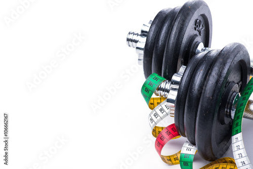Dumbbells with measuring tape on white