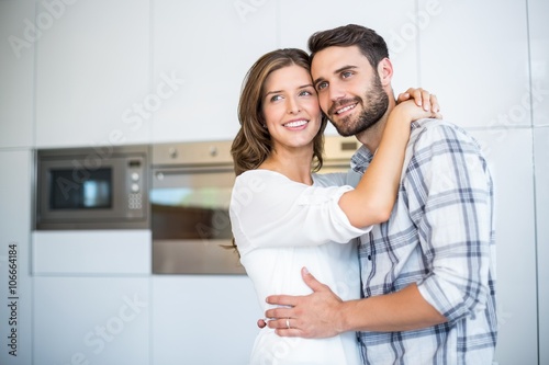 Couple looking away while embracing in kitchen © WavebreakMediaMicro