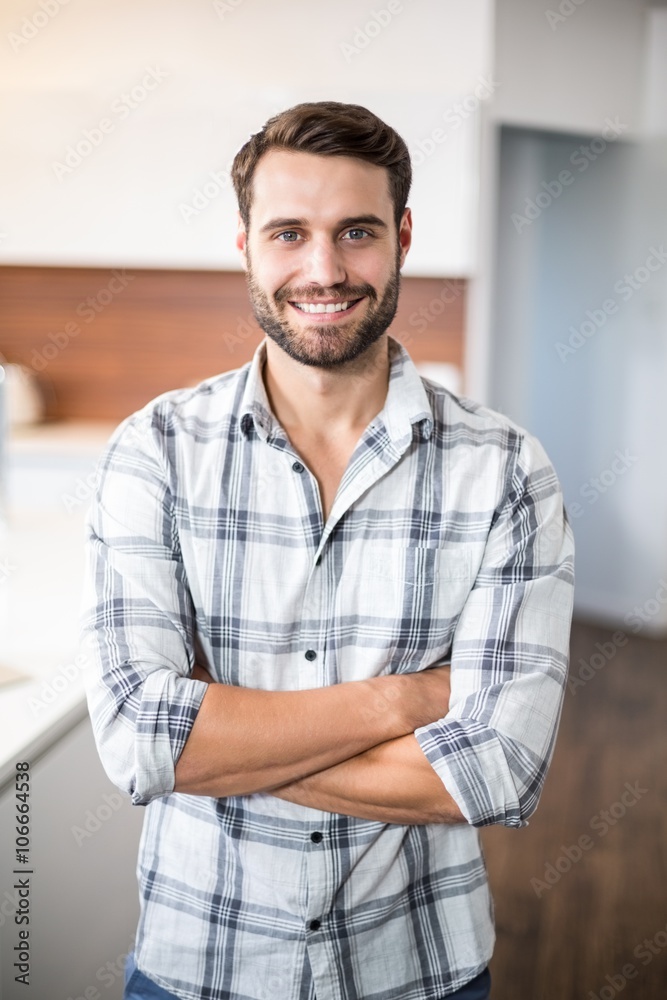 Confident man with arms crossed by kitchen counter Confident man with arms crossed by kitchen counter