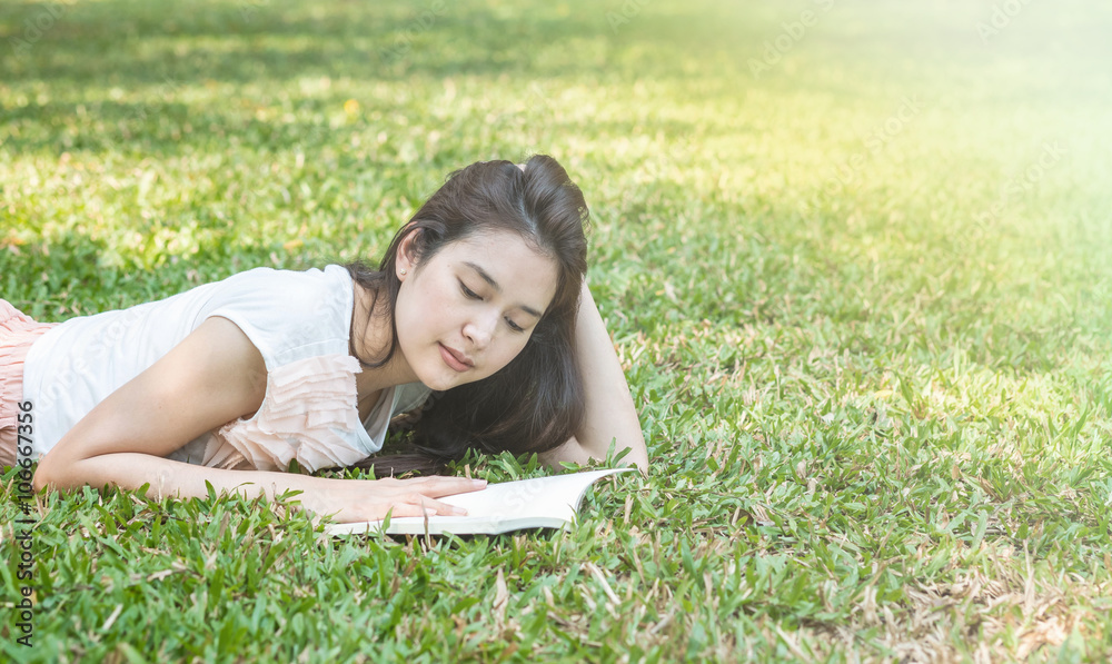 Woman lying on grass field for reading in the park Woman lying on grass field for reading in the park